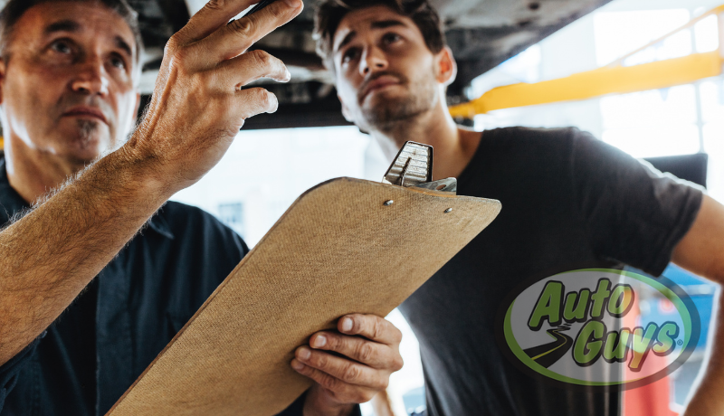 Mechanic discussing pre-purchase inspection with used car buyer